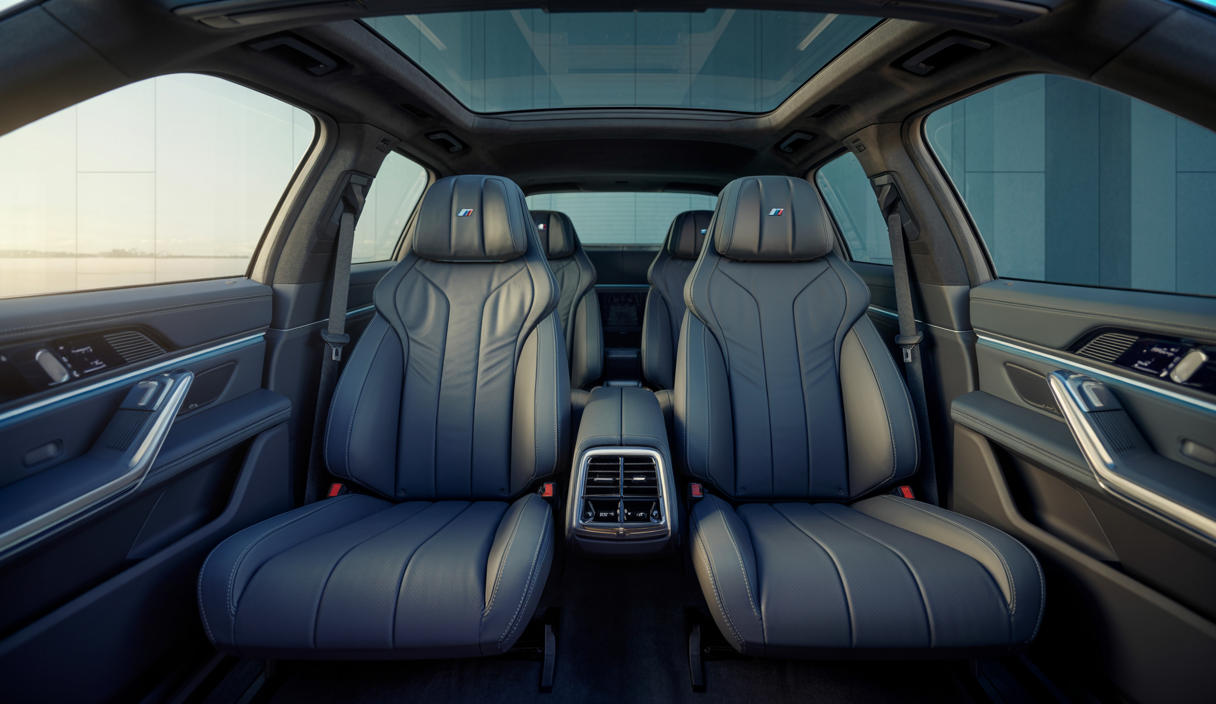 Vue intérieure luxueuse de l’arrière d’une BMW iX M70 avec aménagement spacieux, sièges en cuir premium et éclairage d’ambiance moderne