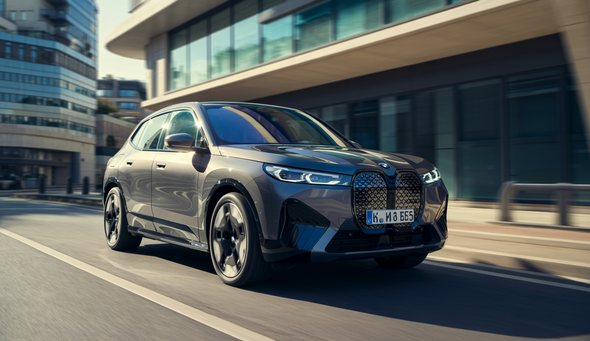 BMW iX xDrive60 électrique SUV gris carbone métallisé sur une route moderne avec éclairage naturel