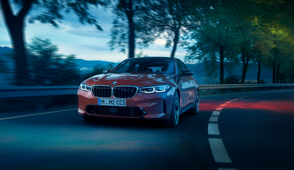 Image dynamique de la BMW M2 CS en pleine vitesse sur une route sinueuse.